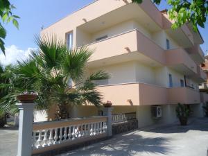 a building with palm trees in front of it at Apartment Marina di Ascea 2 in Castellammare di Velia