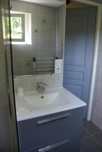 een badkamer met een witte wastafel en een spiegel bij Domisiladore in Latouille-Lentillac