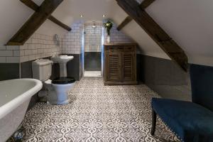 a bathroom with a toilet and a tub and a sink at The Dirty Bottles Inn in Alnwick