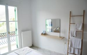 a white bathroom with a mirror and a window at Naxos olive & home in Engares +102 photos