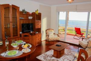 a living room with a table and a view of the ocean at Vista Formosa Funchal in Funchal