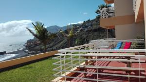 a balcony of a building with chairs and the ocean at Vista Formosa Funchal in Funchal