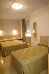 um quarto de hotel com duas camas e uma janela em Hostal Casa Paco em Chilches