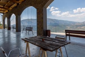 a wooden table and chairs on a patio with a view at Cal Ginés in Llimiana