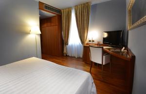 a hotel room with a bed and a tv at Albergo Celide in Lucca