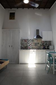 a kitchen with white cabinets and a table at The Stable in Limassol