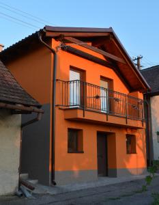 ein orangefarbenes Gebäude mit einem Balkon an der Seite in der Unterkunft Ubytovani U Ruzenky in Velké Bílovice