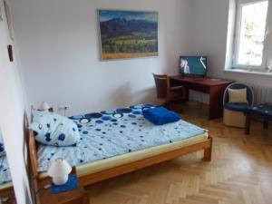 een slaapkamer met een bed en een bureau met een computer bij Apartamenty Nad Wisłą in Skawina