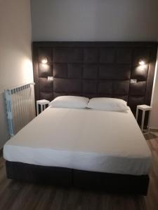 ビシェーリエにあるUna Riga sul Mareのベッドルーム1室(白い大型ベッド1台、テーブル2台付)