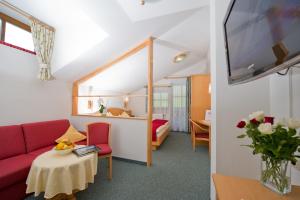 um quarto com um sofá, uma mesa e uma cama em Hotel Landhaus Neumayr em Grossarl