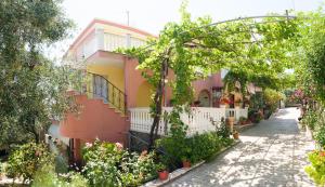 a pink and yellow house with a white fence at Nikolaou Thomas House in Parga