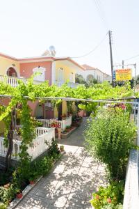 a garden in front of a house with vines at Nikolaou Thomas House in Parga