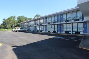 Un edificio con un coche aparcado en un estacionamiento. en Motel 6-Cleveland, TN, en Cleveland