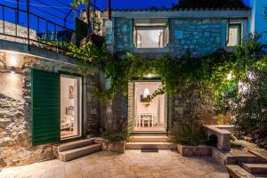 een huis met een groene deur en een patio bij Eternity with pool in Donji Humac