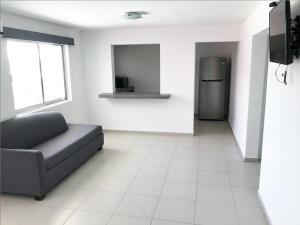 a living room with a couch and a refrigerator at Mona Inn in Mazatlán