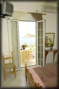 een kamer met een deur naar een tafel met uitzicht bij Atlantis Hotel in Myrties