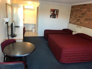 a hotel room with a bed and a couch and a table at Orange Motor Lodge in Orange