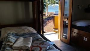 Cama en habitación con puerta a un balcón en Submarino Hostel, en Florianópolis