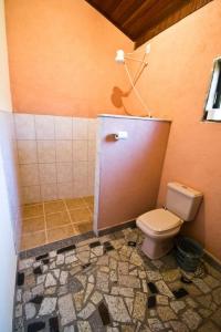 a bathroom with a toilet and a tile floor at Pousada do Vale in Joanópolis