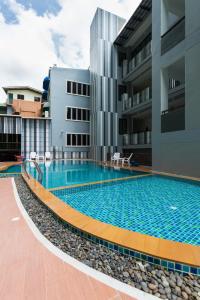 a swimming pool in front of a building at Phranang Place- SHA Extra in Ao Nang Beach