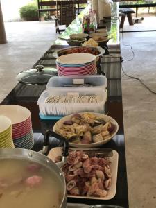 a buffet line with many plates of food on it at Sangtong Beach Resort in Laem Sing