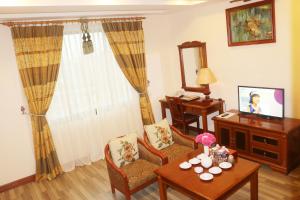 a living room with a table and a television at Central Hotel in Quang Ngai