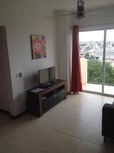 uma sala de estar com uma televisão numa mesa e uma janela em Maggy's House em La Romana