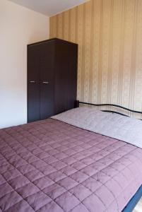 Dormitorio con cama morada y armario negro en Cracow Stay Apartments en Cracovia