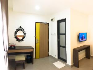 a room with a door and a table and a mirror at Hotel Check-In in Kuala Lumpur