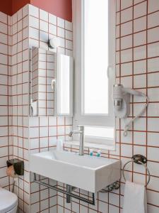 baño con lavabo blanco y ventana en Hotel Riviera, en Anzio