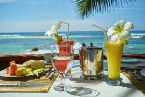 a table with two glasses of drinks on the beach at La Veranda Di Serena in Unawatuna