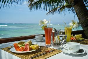 a table with plates of food and drinks on the beach at La Veranda Di Serena in Unawatuna