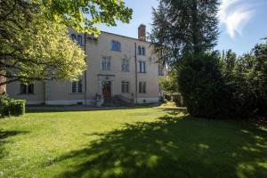une grande maison blanche avec une cour en herbe dans l'établissement Bed and Breakfast Le Château de Morey, à Morey