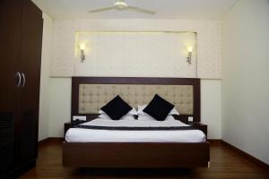 a bedroom with a large bed with a large headboard at Green Park Residency in Kannur