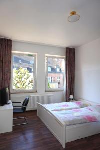 una camera con un letto e due finestre di Artus Hotel a Dusseldorf