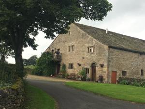 an old stone building with people on a balcony at Love Cottage in Bell Busk