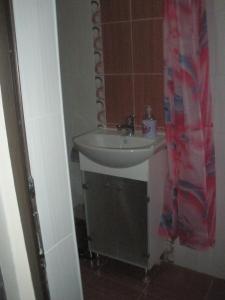 a bathroom with a sink and a shower curtain at Comfort Guest Rooms in Pleven