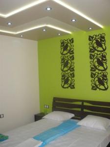 a bedroom with two beds and a green wall at Comfort Guest Rooms in Pleven