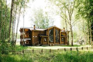 una cabaña de madera en el bosque con una valla en Sanatoriy Serebryany Ples, en Kuzminka