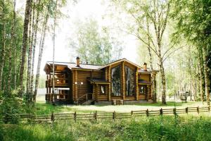 a log cabin in the woods with a fence at Sanatoriy Serebryany Ples in Kuzminka