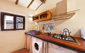 a kitchen with a stove and a washing machine at Villa Amedeo in Rosia