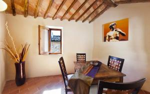 een eetkamer met een houten tafel en stoelen bij Villa Amedeo in Rosia