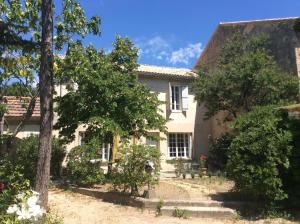 een oud huis met bomen ervoor bij Maison Daumas Billard Français et Piscine in Robion en Luberon