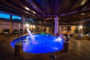 a swimming pool with a fountain in a building at Hostal Rural & Spa Las Vistas in Pastrana