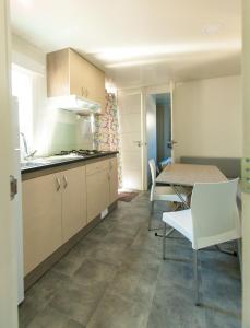 a kitchen and dining room with a table and chairs at Camping el Pinar Platja in Santa Susanna