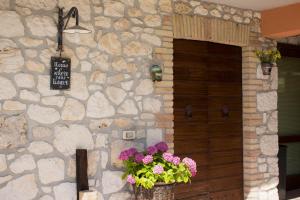 ein Steingebäude mit einer Tür mit einem Blumenkorb in der Unterkunft sapori di bea in Abbateggio