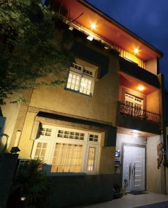 a house with white doors and windows at night at Jiao Xi Yi Dou Hot Spring B&B in Jiaoxi