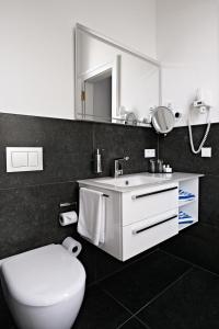 a bathroom with a toilet and a sink and a mirror at Badhotel Bad Brückenau in Staatsbad Brückenau