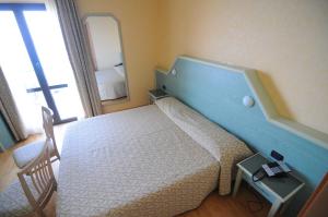 
a hotel room with two beds and a television at Hotel Residence Mondial in Moneglia
