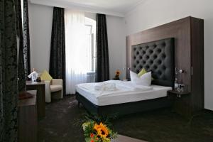 um quarto com uma cama grande e uma janela grande em Badhotel Bad Brückenau em Staatsbad Brückenau